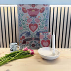 1-1-NB-Ekelund_Varkansla_med_ljusstake_Megan_vit_pa_bank_med_blommor